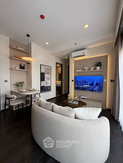 Modern living room with stylish decor and wall-mounted TV in a cozy apartment.
