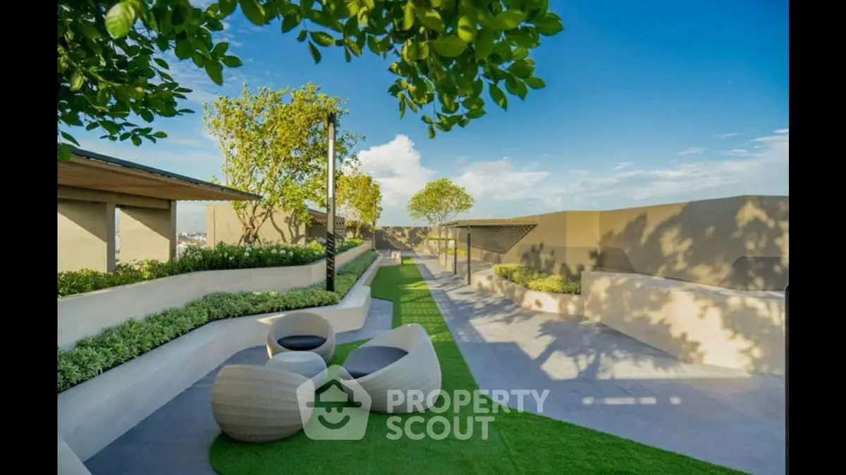 Luxurious rooftop garden with modern seating and lush greenery under a clear blue sky.