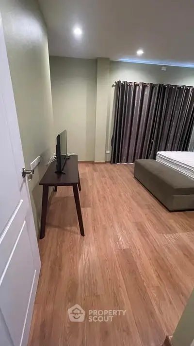 Spacious bedroom with wooden flooring and modern decor