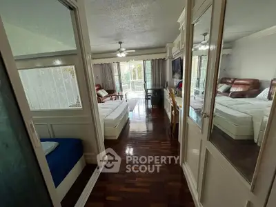 Spacious living room with hardwood floors and large windows leading to a balcony, perfect for relaxation.