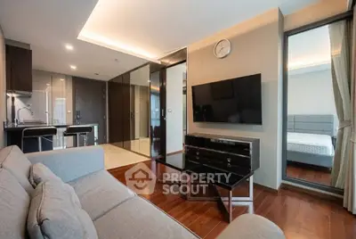 Modern living room with sleek furniture and open kitchen layout in luxury apartment.