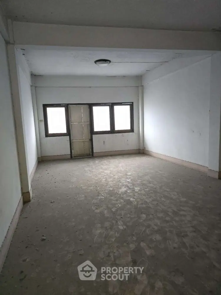 Spacious empty room with large windows and natural light, ideal for customization.