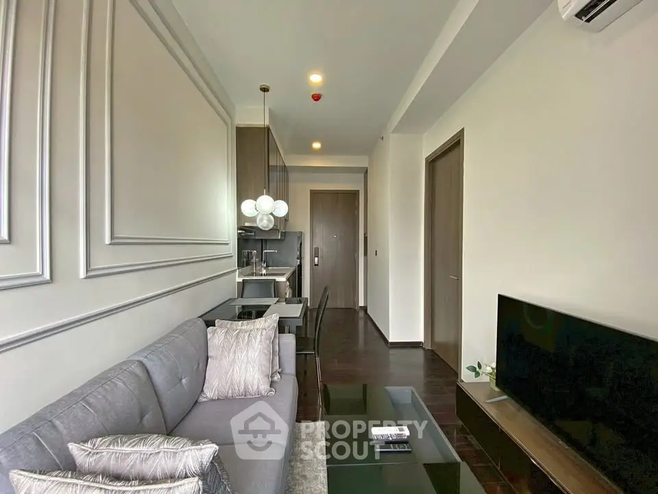 Modern living room with elegant decor and open layout, featuring a cozy sofa and sleek TV setup.