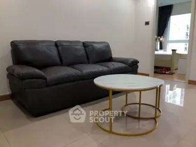 Modern living room with sleek leather sofa and stylish round coffee table.