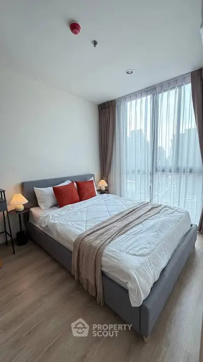 Modern bedroom with large window and stylish decor in urban apartment