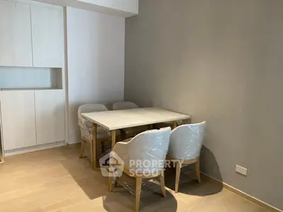 Modern dining area with elegant chairs and wooden table in a cozy apartment corner.