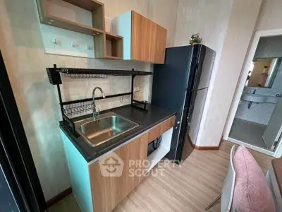 Modern compact kitchen with sleek black fridge and stylish wooden cabinets