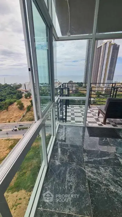 Stunning balcony with panoramic view and modern glass railing in high-rise building.