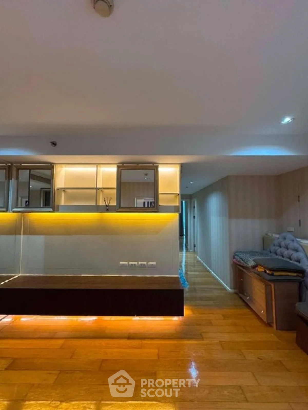 Spacious modern living room with wooden flooring and ambient lighting