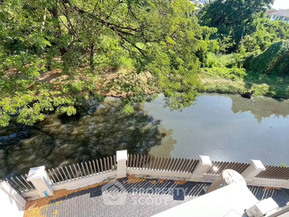 Scenic view of lush greenery and tranquil water from a property balcony, perfect for nature lovers.