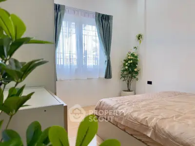 Cozy bedroom with natural light and elegant decor, perfect for relaxation.