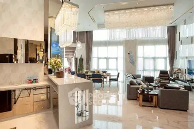 Luxurious open-plan living room with elegant chandeliers and marble flooring