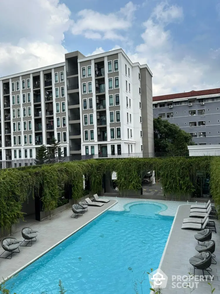 Modern apartment building with luxurious pool and lush greenery, perfect for urban living.