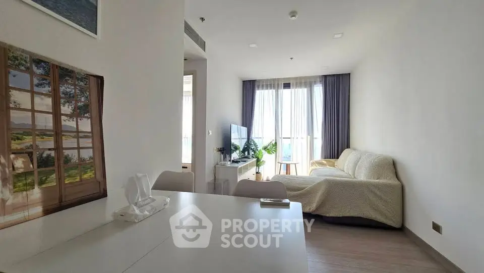 Bright and cozy living room with large window and modern decor