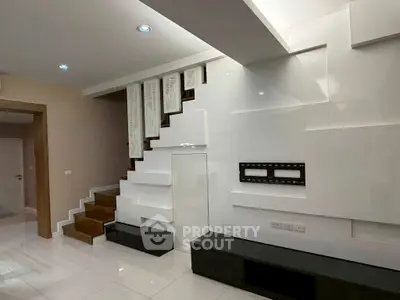 Modern interior with sleek staircase and wall-mounted TV setup