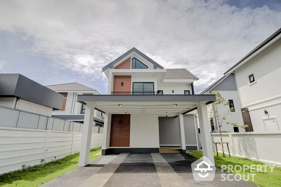 Modern two-story house with carport and landscaped yard in suburban neighborhood.