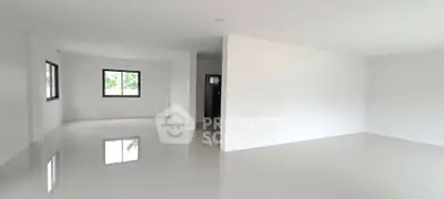 Spacious open-plan living area with glossy tiled floors and large windows.