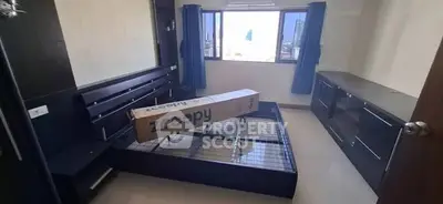 Spacious bedroom with large windows and modern furniture setup.