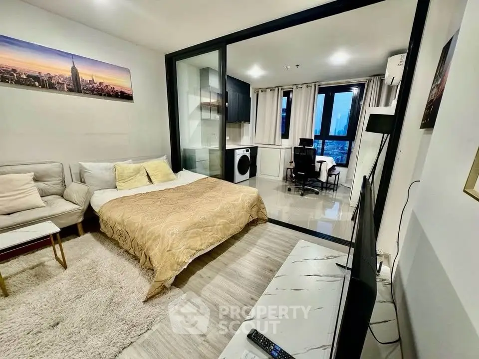 Modern studio apartment with open layout and city view, featuring cozy living area and in-unit washer.