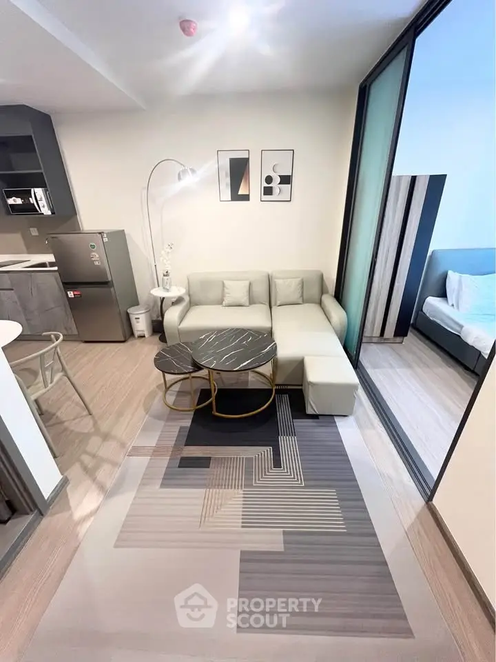 Modern living room with stylish decor and open layout adjacent to a cozy bedroom.