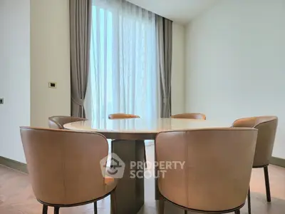 Elegant dining area with round table and leather chairs in modern apartment