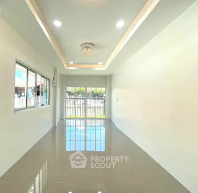 Spacious modern living room with glossy tile flooring and elegant chandelier