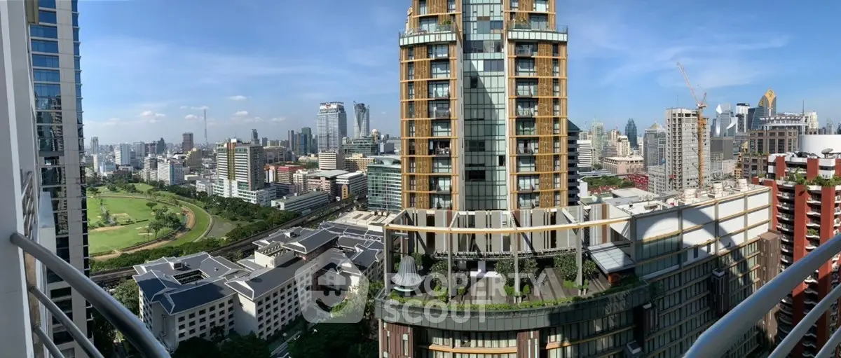 Stunning cityscape view from a high-rise balcony showcasing modern architecture and lush greenery.
