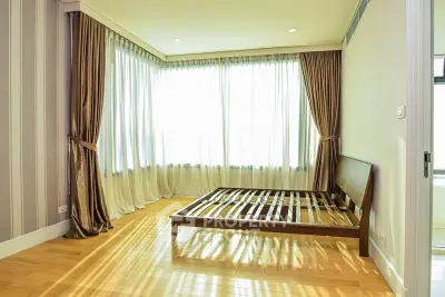 Spacious bedroom with large windows and wooden flooring