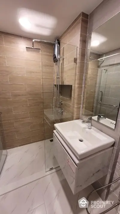 Modern bathroom with glass shower and sleek vanity in contemporary design.