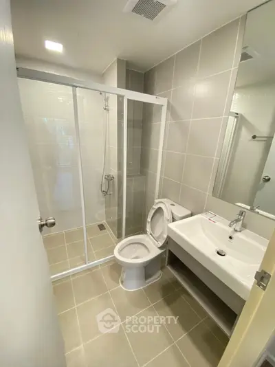 Modern bathroom with glass shower and sleek fixtures in a contemporary home.