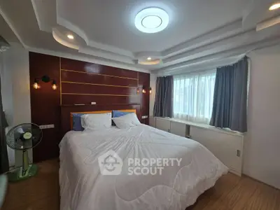 Spacious bedroom with modern ceiling design and cozy lighting