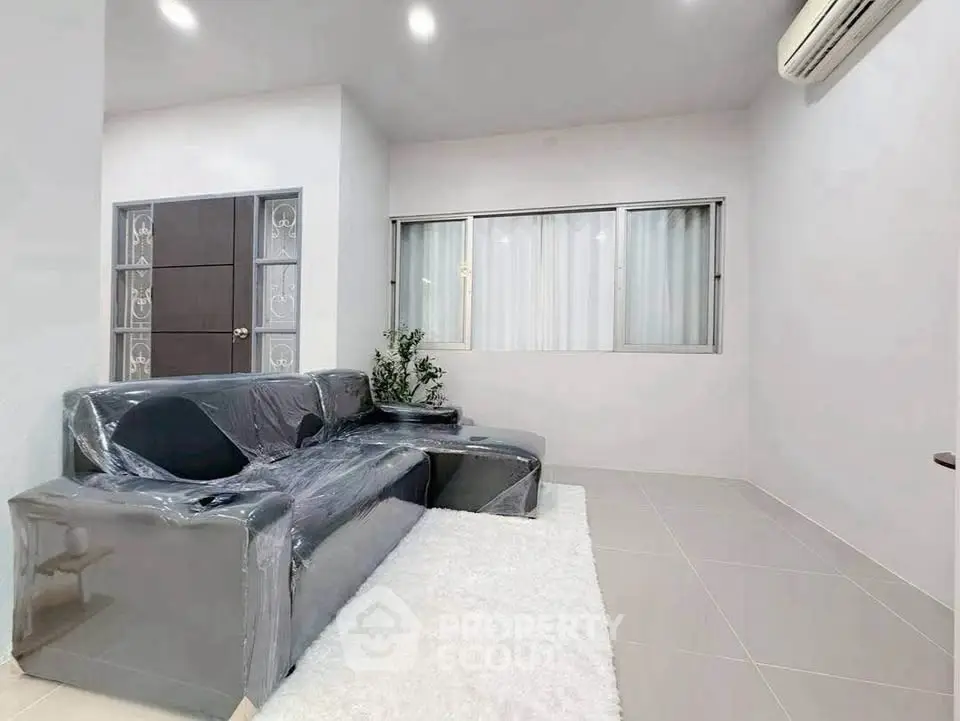Modern living room with sleek furniture and air conditioning, perfect for comfortable living.