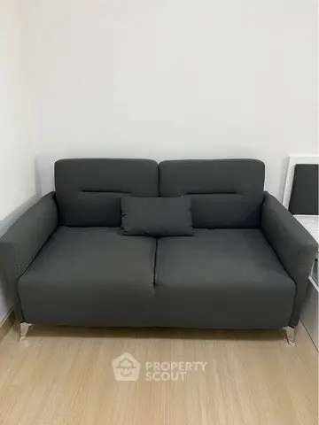 Modern gray sofa in minimalist living room with wooden flooring