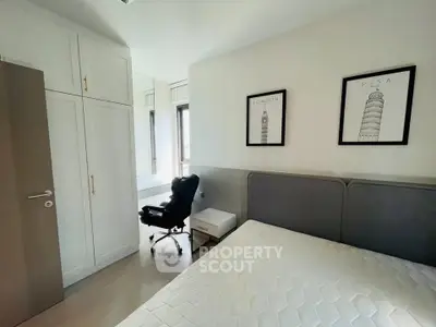 Modern bedroom with stylish decor and ample natural light, featuring a comfortable bed and sleek storage solutions.
