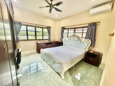 Spacious bedroom with elegant bed and ample natural light, perfect for relaxation.
