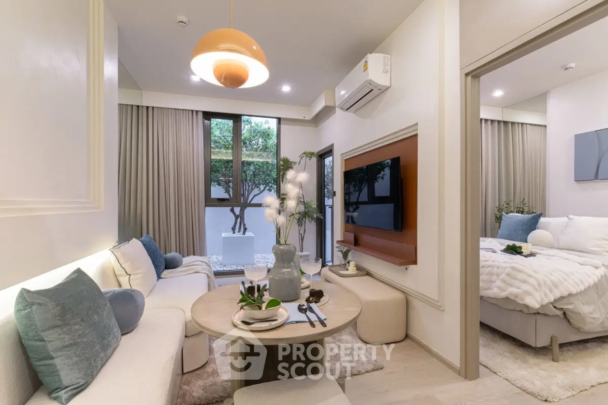 Modern living room with cozy seating and stylish decor adjacent to a chic bedroom.