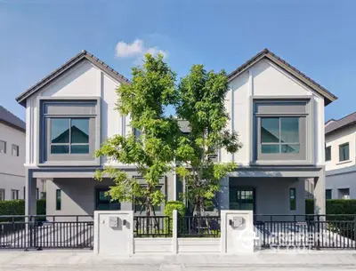 Modern duplex house with sleek design and lush greenery in suburban neighborhood