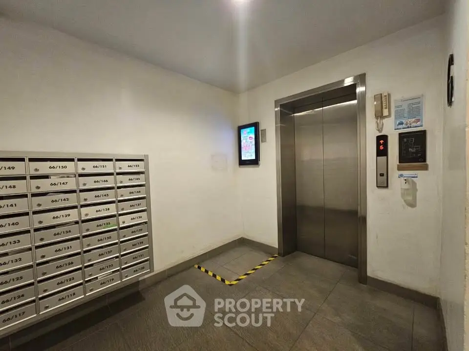 Modern building elevator lobby with mailboxes and digital display