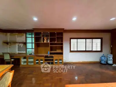 Spacious living room with wooden flooring and built-in shelving, ideal for modern living.