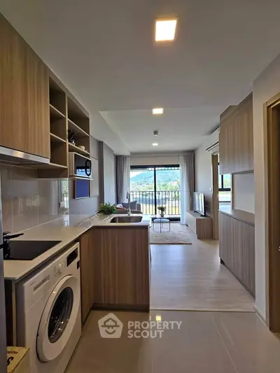 Modern open-layout kitchen with washing machine and living room view