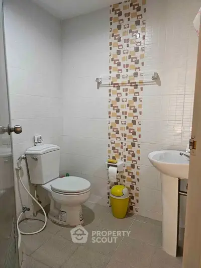 Modern bathroom with stylish tile accent and sleek fixtures in a contemporary home.
