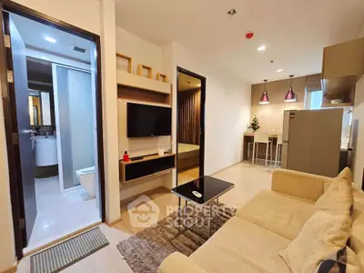 Modern open-plan living room with cozy sofa and kitchen area in stylish apartment.