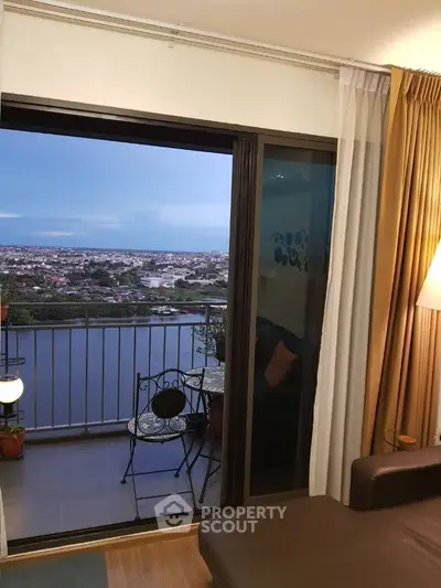 Charming apartment with stunning balcony view overlooking a serene river and cityscape, perfect for relaxation.