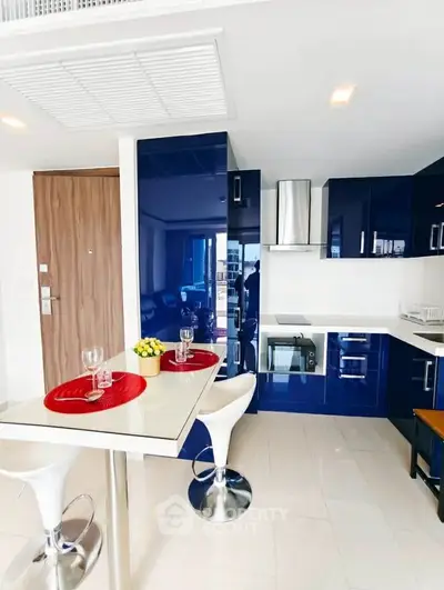 Modern kitchen with sleek blue cabinets and breakfast bar in a stylish apartment.