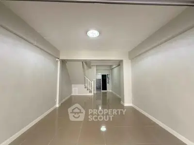 Spacious open-plan interior with sleek tile flooring and modern lighting, ideal for versatile living arrangements.