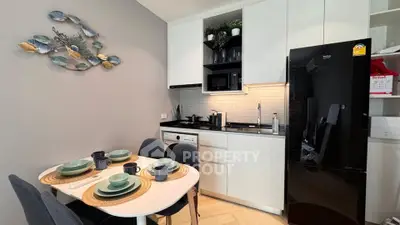 Modern kitchen with sleek black fridge and stylish dining area