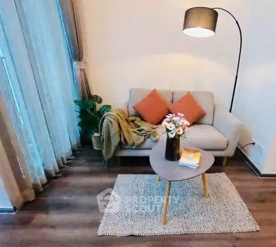 Cozy living room with modern decor, featuring a stylish sofa, elegant lamp, and chic coffee table.