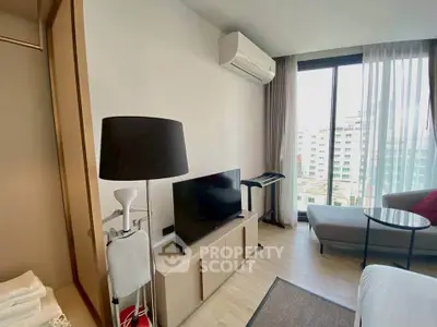 Modern living room with city view, featuring sleek furniture and natural light.