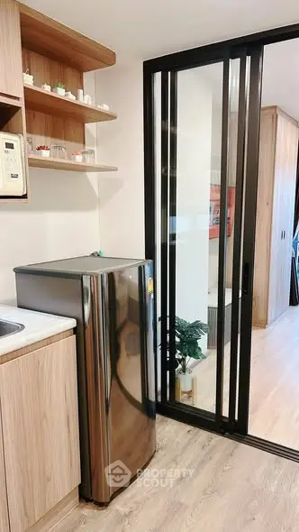 Modern kitchen with sleek fridge and sliding glass door in stylish apartment
