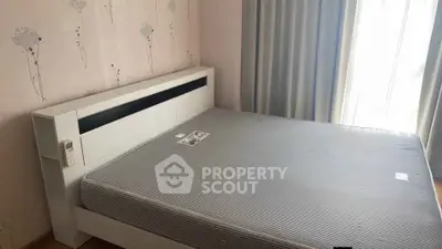 Spacious bedroom with modern bed and natural light through large window.